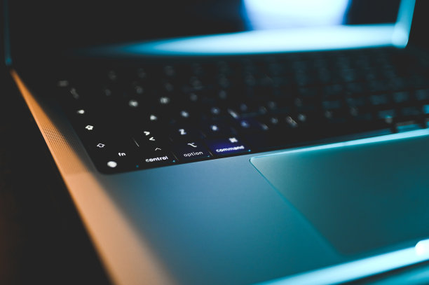 霓虹灯下的笔记本电脑键盘特写。图片下载