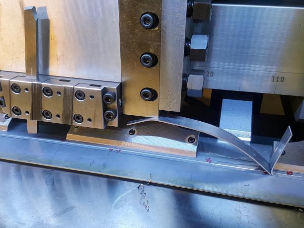 一台机器正在桌子上切割金属零件的照片。图片下载