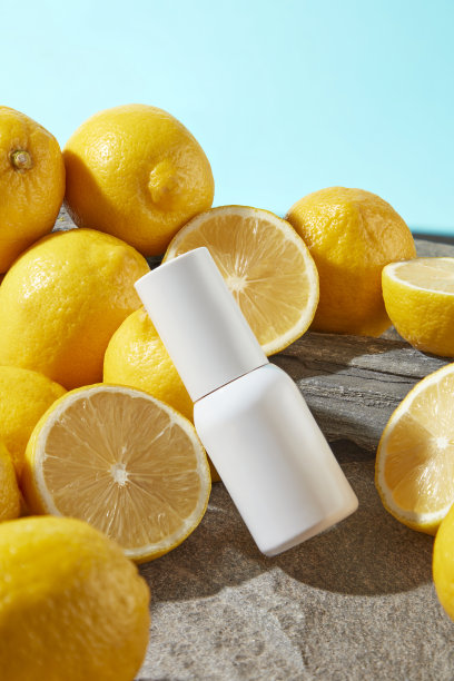 一个白色的没有标签的管子放在石头上，靠在黄色的柠檬上。广告模型，留白设计，高角度拍摄照片图片下载