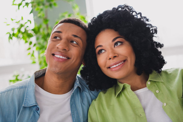 漂亮的年轻男子的照片女孩坐在沙发拥抱看空空间现代室内室内舒适的日光公寓客厅图片下载