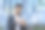 特写照片，一个微笑的年轻印度男子穿着西装坐在办公大楼附近使用平板电脑图片下载