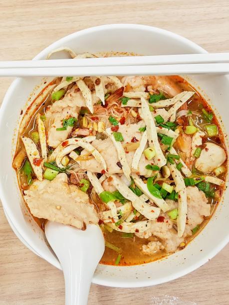 用筷子和勺子盛一碗汤的照片。图片下载