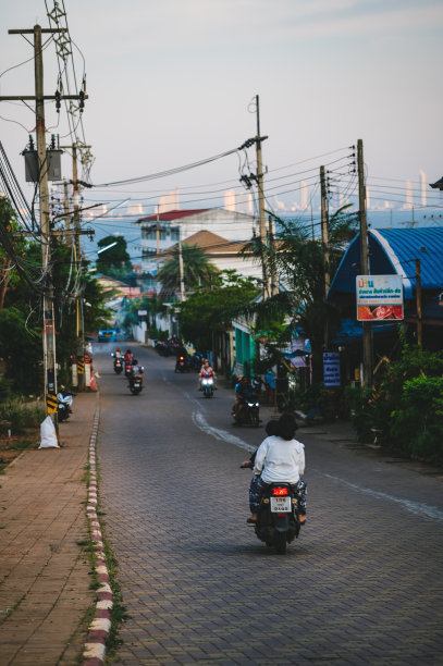 不熟悉的游客或当地人骑摩托车在高兰岛与芭堤雅市的城市景观。图片下载