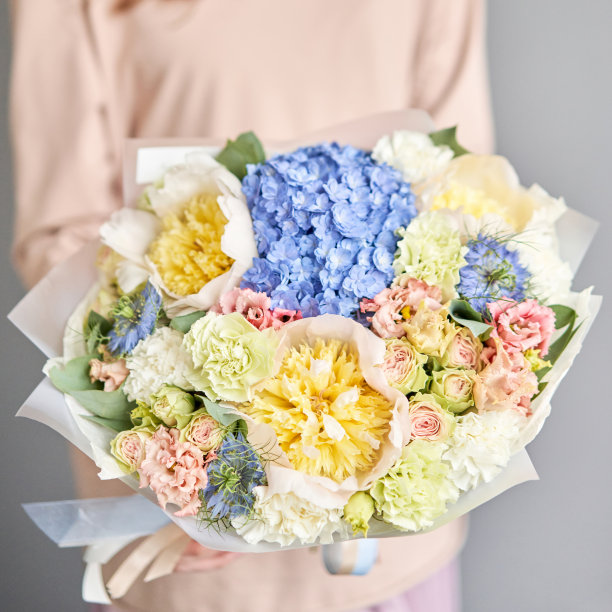 美丽的花束与牡丹花在女人的手中。花店概念。美丽新鲜的花束。鲜花交付图片下载