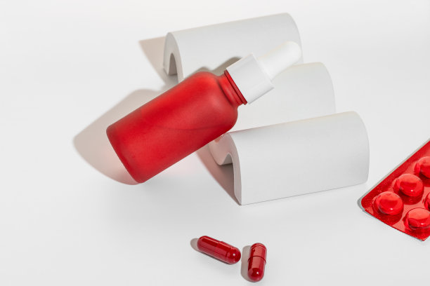 在白色混凝土平台上模拟药片，药物和维生素胶囊以及面部或身体滴管瓶血清的组成。产品演示图片下载