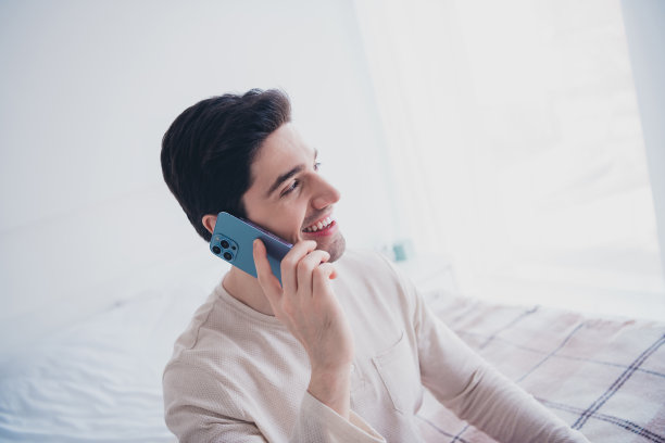 英俊开朗的男人打电话的照片早晨舒适的房间白色的日光室内室内图片下载