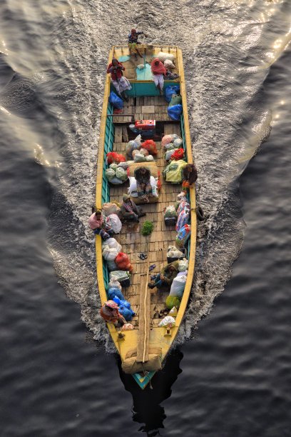 人们带着蔬菜和货物乘船旅行的真实景象图片下载