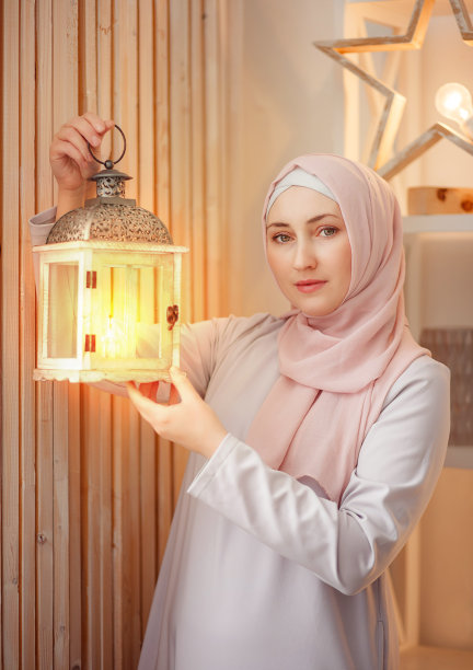 穆斯林妇女手里拿着一盏灯。斋月。图片下载