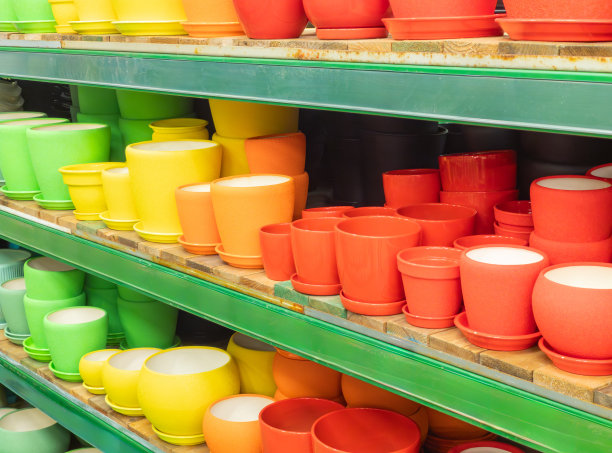 商店或温室里的空花盆。商店里的陶瓷或塑料花盆。商店货架上五颜六色的花盆。图片下载