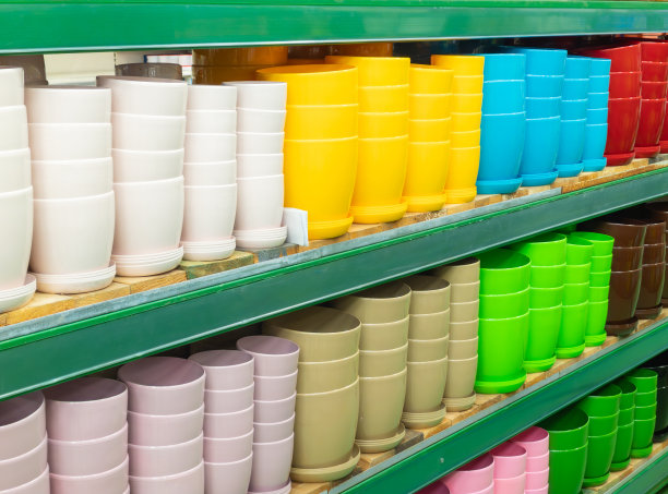 商店或温室里的空花盆。商店里的陶瓷或塑料花盆。商店货架上五颜六色的花盆。图片下载