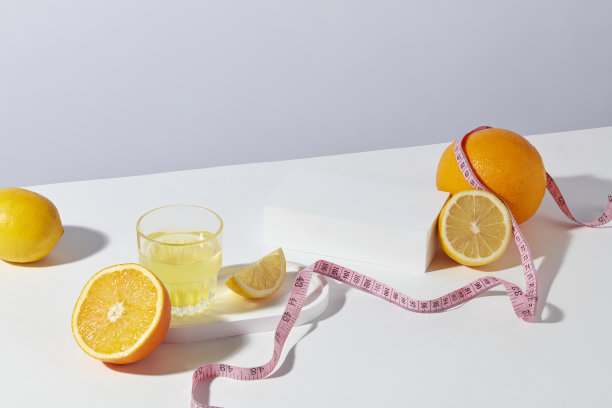 高角度拍摄的减肥概念照片，在白色纹理与柑橘水果组成，包括柠檬和橙子，空白的白色讲台放置在白色桌子的中心，以展示产品图片下载