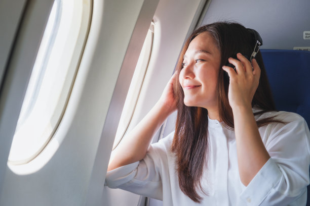 图为一名女子在飞机上戴着耳机听音乐图片下载