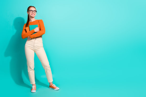 可爱的女人戴着眼镜抱着书看折扣空空间孤立在绿松石色背景的全身照片图片下载