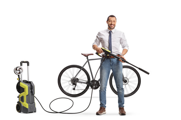 一名商人在自行车前举着一台高压喷水枪图片下载