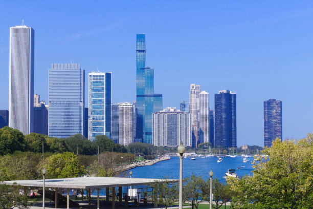 芝加哥的城市景观:密歇根湖海滨，帆船，木板路，行人，树木与摩天大楼和塔楼的城市天际线相映衬。风景如画的城市风景照片。图片下载