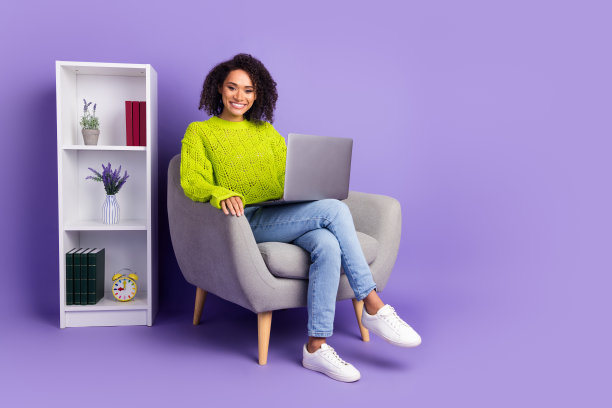 可爱的年轻女士的全身照片坐在扶手椅上网本办公室穿着时尚的绿色服装孤立的紫色背景图片下载