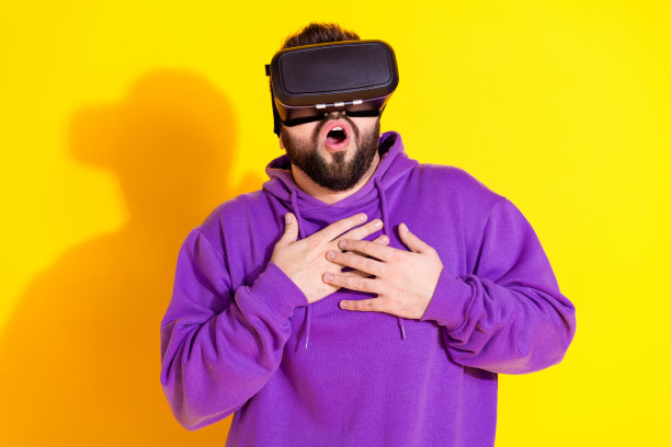 有趣的照片害怕好男人穿紫色时尚的衣服令人兴奋的图片vr眼镜孤立的黄色背景图片下载