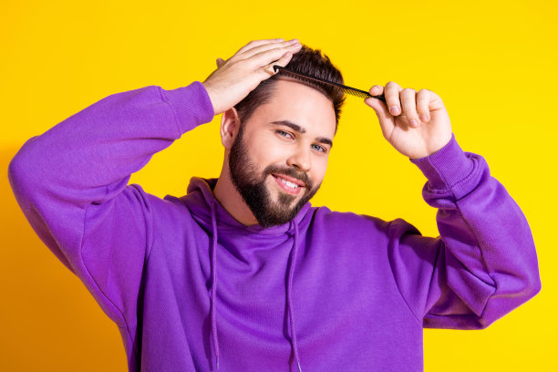 照片中漂亮帅气的男人穿着紫色时髦的衣服，梳着头发孤立在黄色的背景上图片下载