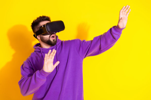 照片中的兴奋高兴的好男人穿着紫色时髦的衣服3d眼镜看起来空白空间孤立在黄色的背景图片下载