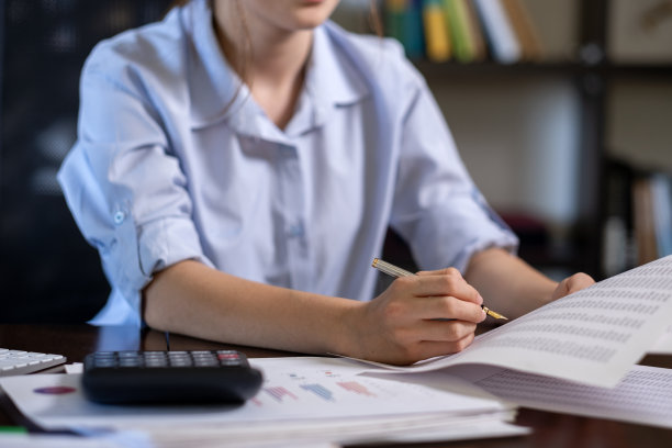 不知名的女人在检查纸上的数据图片下载