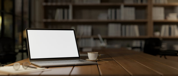 在舒适的阅读室或家庭办公室里，笔记本电脑模型放在木桌上的特写照片。图片下载