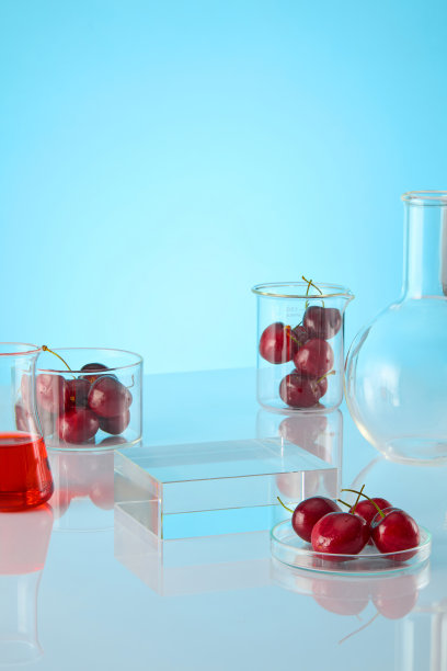 产品广告图片与实验室和樱桃概念在浅蓝色背景。桌子中央的展示平台，实验室里的一些玻璃器皿旁边，文字的空白空间图片下载