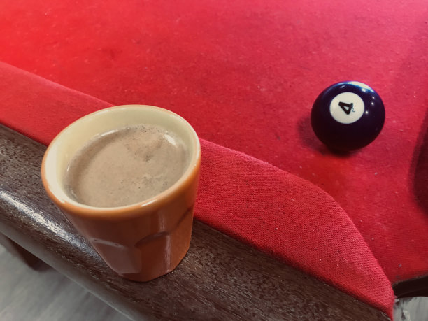 斯诺克和咖啡。一杯咖啡。喝咖啡。咖啡休息。绿色的杯子。一杯咖啡在机器里。木背景上的一杯咖啡。台球桌上的一杯咖啡。俯视图图片下载