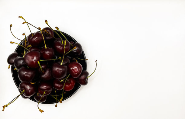 新鲜的红樱桃水果在盘子上的白色背景的特写。高质量照片图片下载