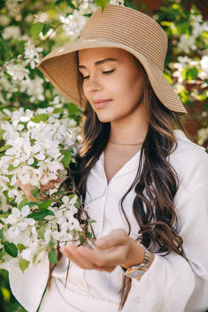 夏日花园或公园里戴着帽子、穿着白色衣服的年轻女子图片下载