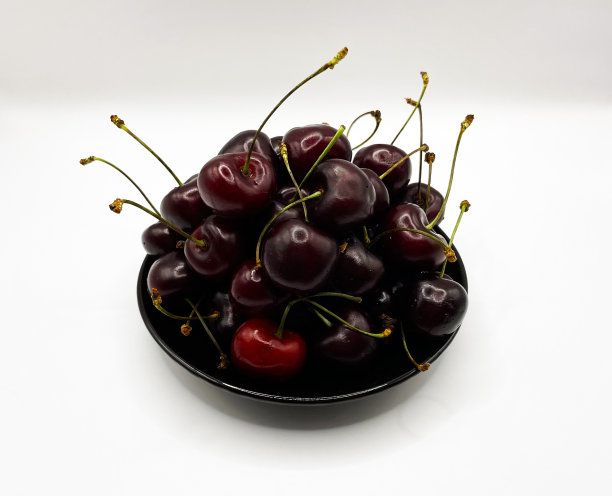 新鲜的红樱桃水果在盘子上的白色背景的特写。高质量照片图片下载