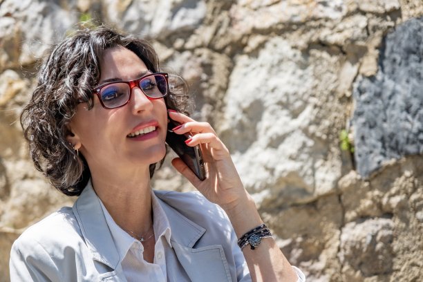 黑发女人坐在那里打电话。图片下载