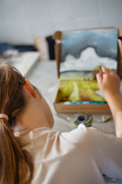 小女孩坐在家里的桌子边画画图片下载