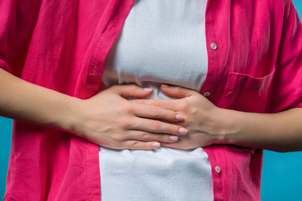 年轻女子用手捏着肚子。腹痛，胃痛图片下载