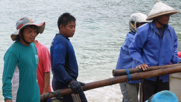 在Ngrenehan海滩上，一群渔民在公海上搜寻了一夜之后，将这艘船推向海滩。图片下载