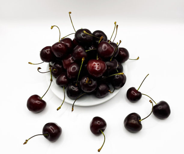 新鲜的红樱桃水果在盘子上的白色背景的特写。高质量照片图片下载