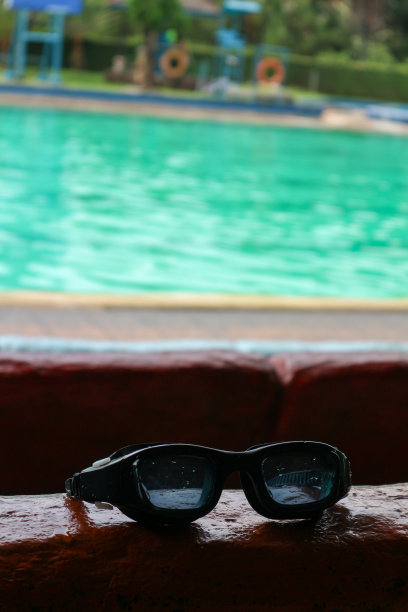 黑色泳镜，背景是游泳池图片下载