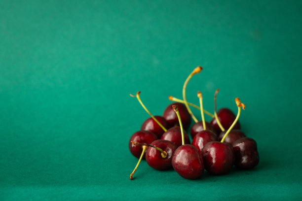 美味又健康的樱桃。成熟的水果，在美丽的深绿色背景下，充满了维生素图片下载