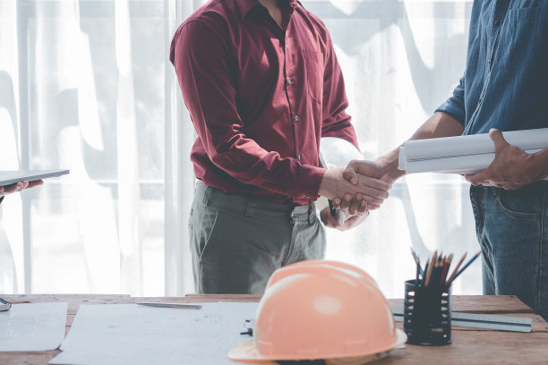 建筑师和建筑工程师在办公室施工现场完成协议后，手牵着手进行团队合作和合作理念。特写照片图片下载