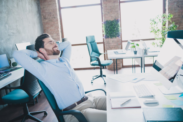 成功优雅的男人的照片，坐在椅子手臂在头后，穿衬衫阁楼室内现代办公室室内图片下载