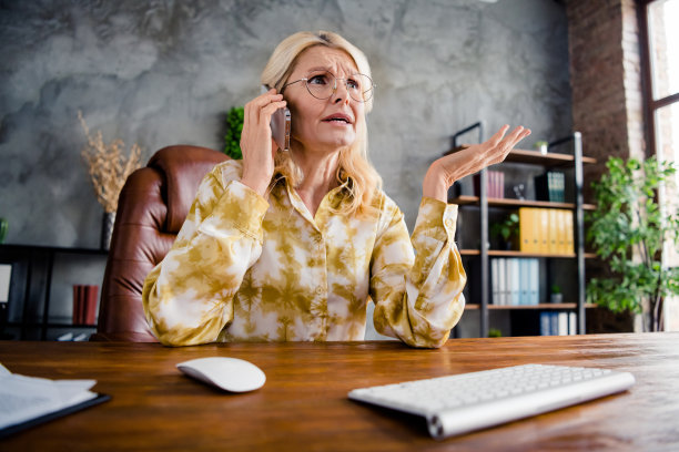 照片肖像可爱成熟的女人打电话强调困惑穿着时髦的衬衫办公室白天光家室内工作空间图片下载