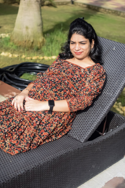 一名怀孕的印度妇女在户外拍摄怀孕照片，手放在肚子上，印度孕妇在社会公园穿着孕妇装把手放在肚子上，怀孕的孕妇在户外拍摄图片下载