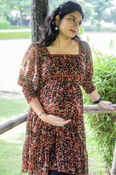 一名怀孕的印度妇女在户外拍摄怀孕照片，手放在肚子上，印度孕妇在社会公园穿着孕妇装把手放在肚子上，怀孕的孕妇在户外拍摄图片下载