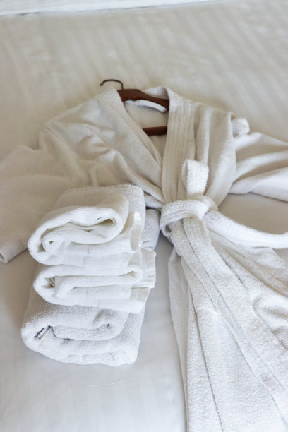 白色睡袍和床上折叠毛巾的图片/优雅和放松的卧室环境图片下载