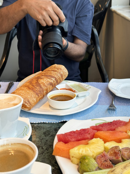 一个人在拍摄完美的印度早餐/印度薄饼和水果沙拉的照片图片下载
