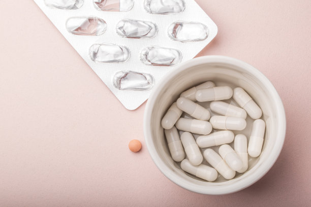 粉色背景上的药丸顶视图。白色胶囊，粉色药丸，空药丸起泡。抗过敏药，抗生素，补品。医学、保健理念。病毒(病毒性)、流感疾病。高质量照片图片下载