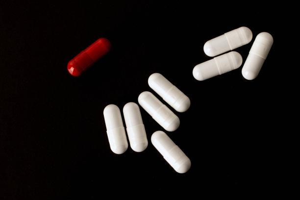 药片。医药药丸和胶囊。红色胶囊。孤立在一个黑色的背景。过敏药，抗生素，补品。医学、保健理念。病毒(病毒性)、流感疾病。高质量照片图片下载