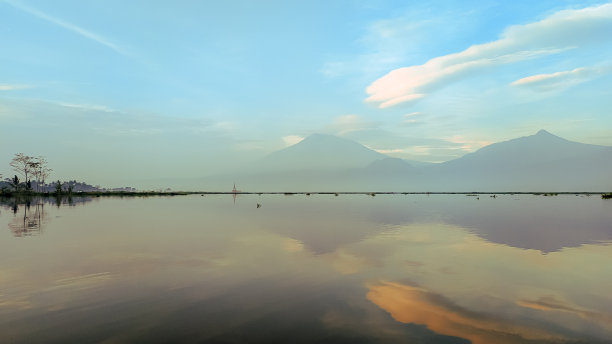 群山倒映在拉瓦坪湖上，以美丽的夕阳天空为背景图片下载