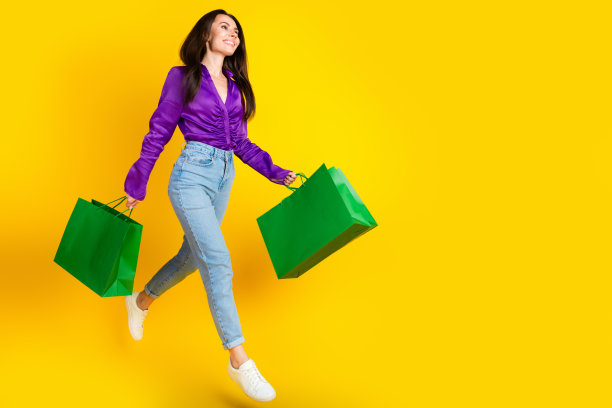 照片正面的女士走走侧面拿着购物袋孤立明亮的颜色背景图片下载