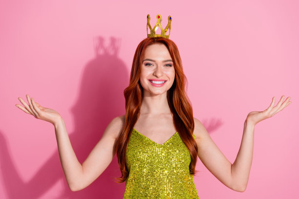 照片漂亮的年轻女子皇冠持有空空间穿闪亮的顶部孤立在粉红色的背景图片下载