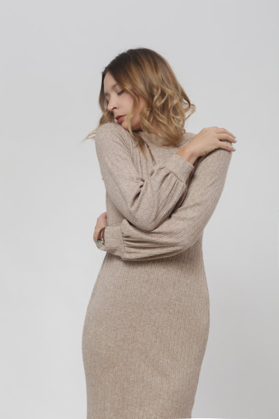 系列工作室照片的女模特在针织米色中长裙，秋冬时装系列。图片下载